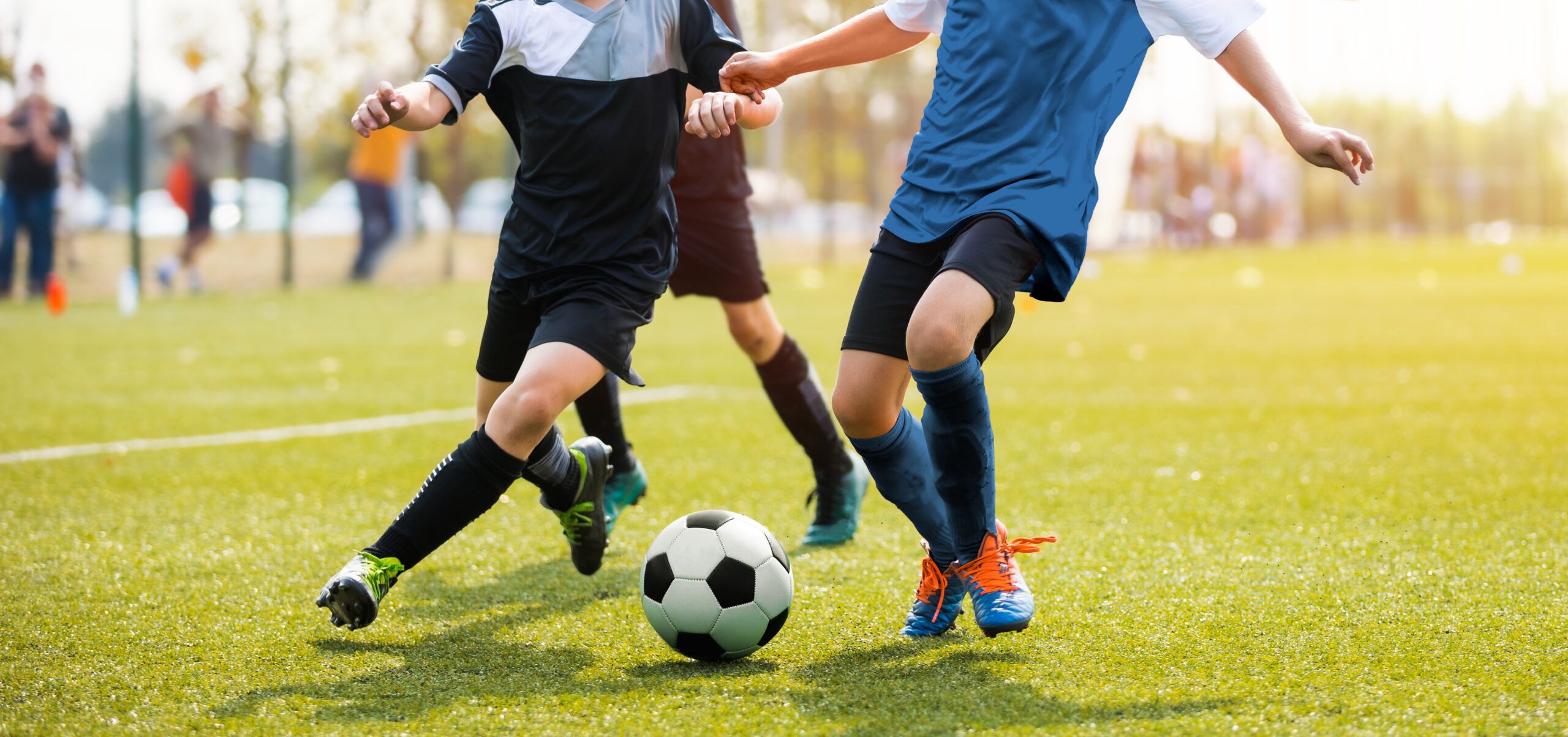 Two soccer players battle for possession of the ball.