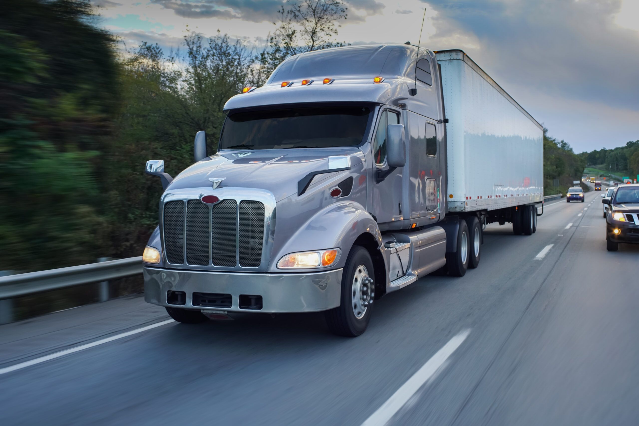 An 18-wheel truck drives on the highway.