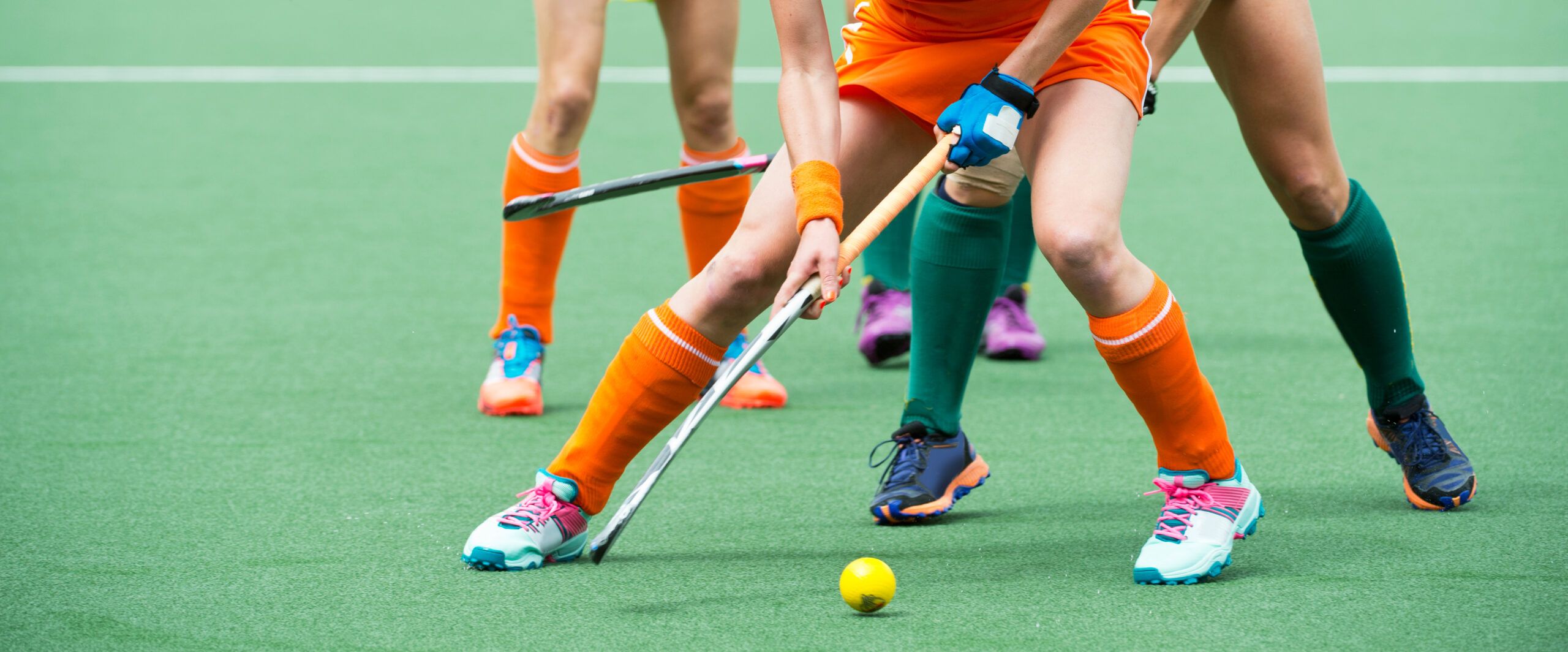 Field hockey players battle for possession of the ball.