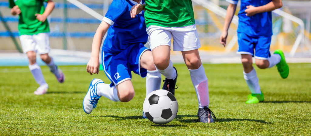 Soccer players run after the ball.